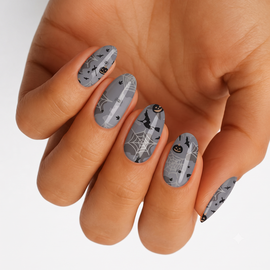 Grey matte semi-cured gel nail wraps with Halloween spiderwebs, bats, pumpkins and witch design