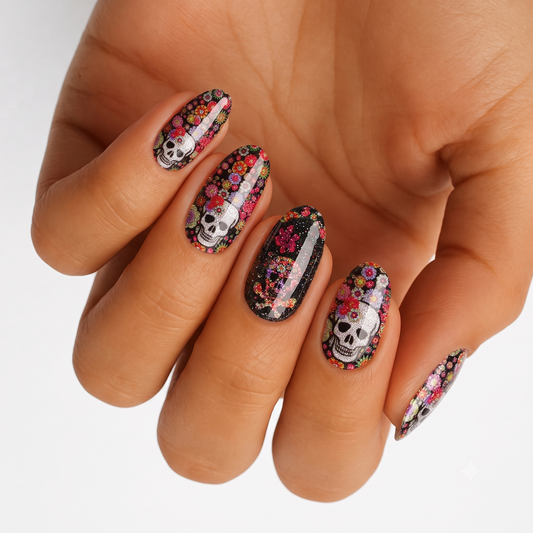 Black nail wraps with glittery sugar skulls and colorful floral Day of the Dead design.