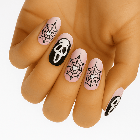 Pink nail art with black spider webs and ghost designs for Halloween manicure on hand