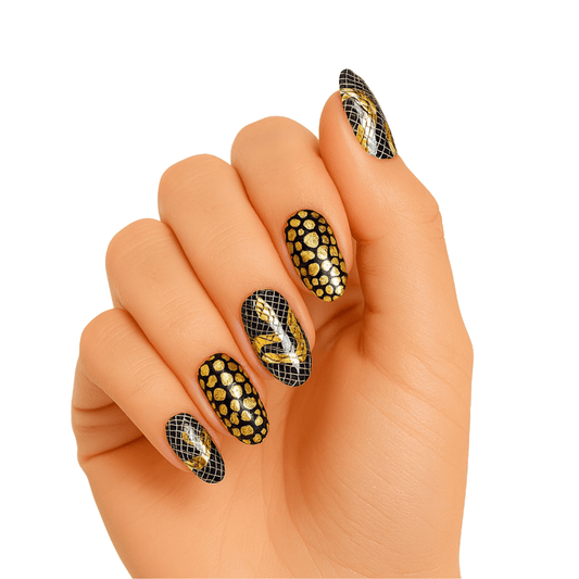 Black and gold snake scale gel nail wraps on hand showing textured serpentine pattern