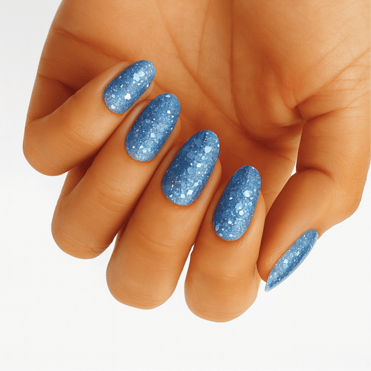 Blue glitter nail wraps applied on hand showing sparkly winter manicure design