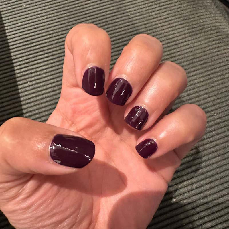 Dark purple glossy nail wraps on hand showing aubergine colour at-home manicure