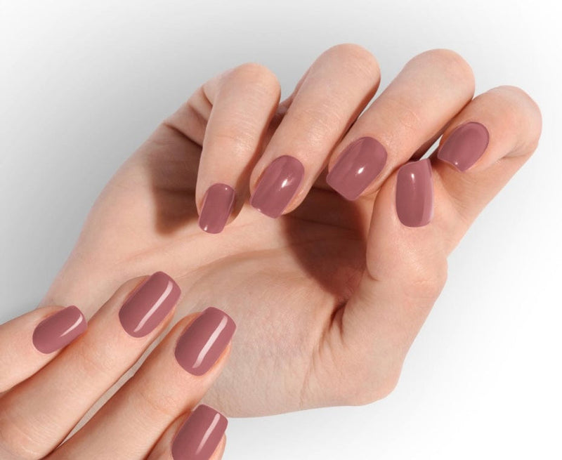Blush pink gel nail wraps on hands displaying glossy mauve at-home manicure finish