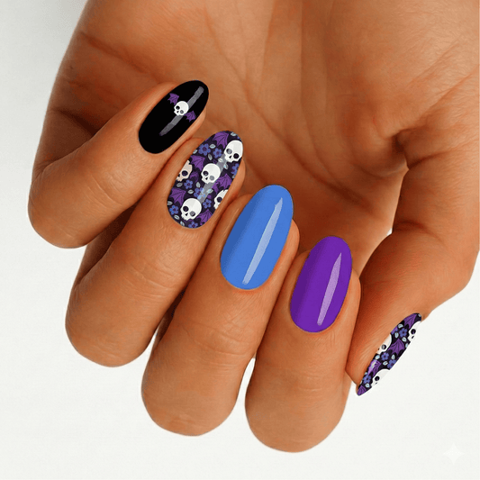 Gothic skull pattern nail art on hand featuring black, purple and blue gel nails