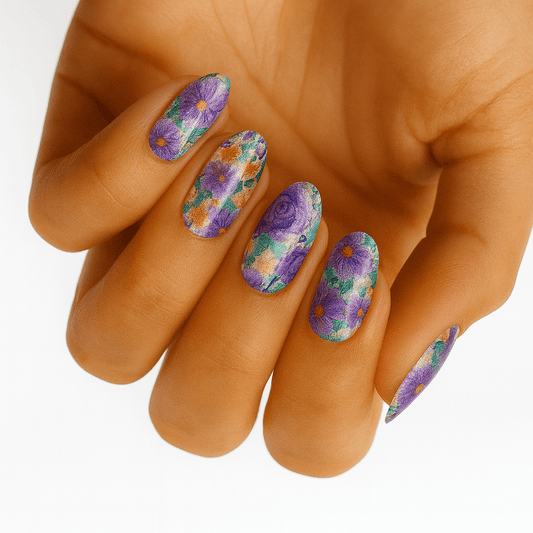 Colourful floral nail wraps on hand featuring purple roses and chrome finish