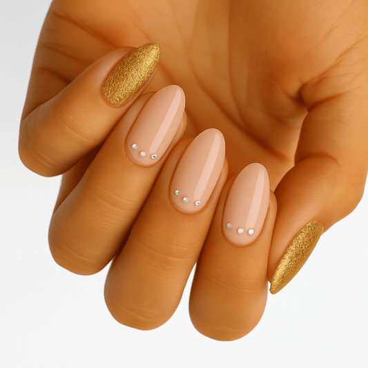 Hand wearing bronze glitter and nude nail wraps with white dots nail art design