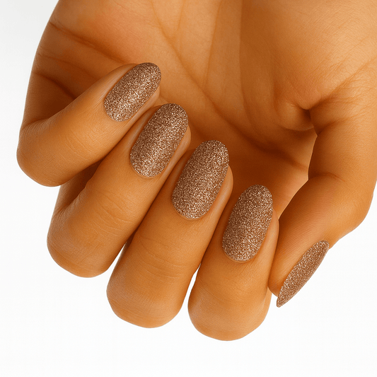 Bronze glitter nail wraps on hand showing metallic textured manicure finish