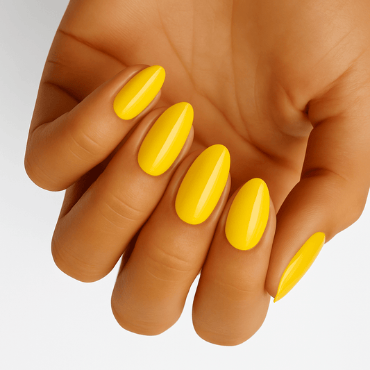 Bright yellow glossy nail wraps on hand showing vibrant at-home manicure