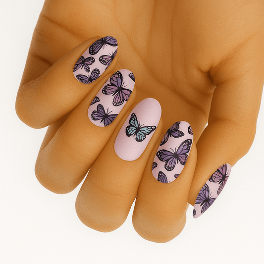 Purple butterfly nail wraps on hand showing pink base with black butterfly pattern manicure
