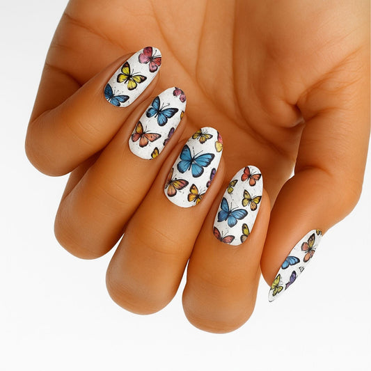Colourful butterfly nail art wraps applied on hand showing vibrant manicure design
