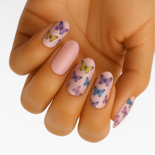 Hand displaying pink butterfly nail wraps with colourful monarch and blue butterfly designs