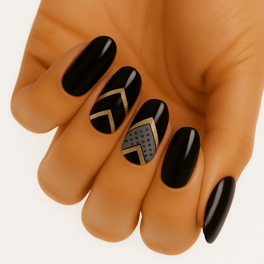 Black gel nail wraps with gold geometric chevron patterns on hand for chic nail art