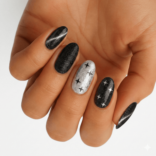 Black glitter and silver star nail wraps on hand showing elegant monochrome manicure