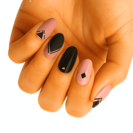 Hand wearing black and pink gel nail wraps with geometric triangle patterns for at-home manicure