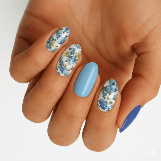 Blue floral nail wraps with daisy pattern on hand showing spring nail art design