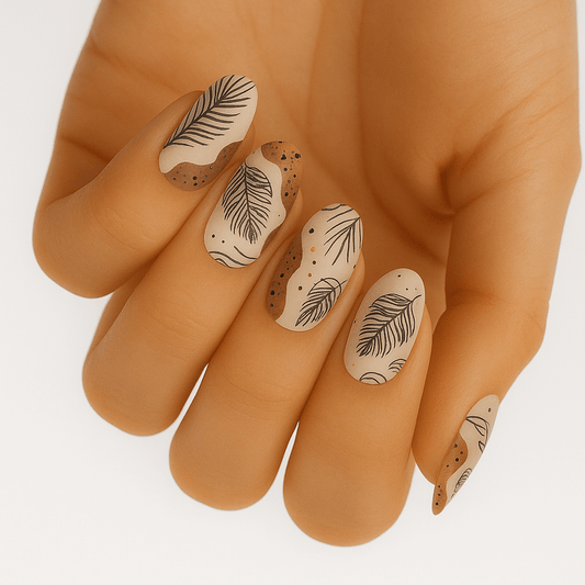 Nude nail wraps with black palm leaf pattern on hand showing tropical nail art design