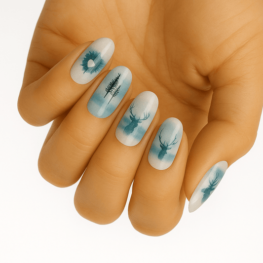 Blue watercolour nail wraps on hand featuring woodland stag and tree silhouettes