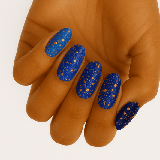 Blue glitter nail wraps with gold sparkles on hand showing party nail art design