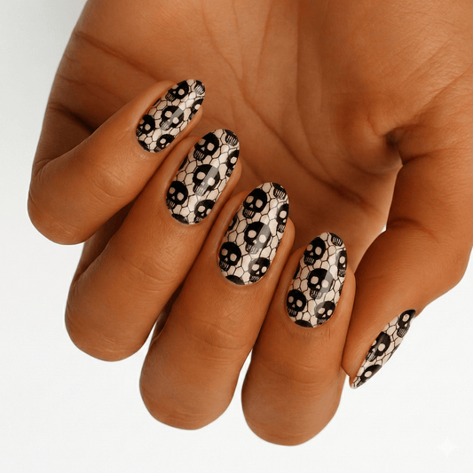 Hand displaying black skull fishnet nail art wraps with glow-in-the-dark gothic design