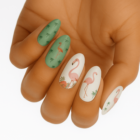 Tropical flamingo nail wraps on hand featuring pink flamingos and green palm tree patterns