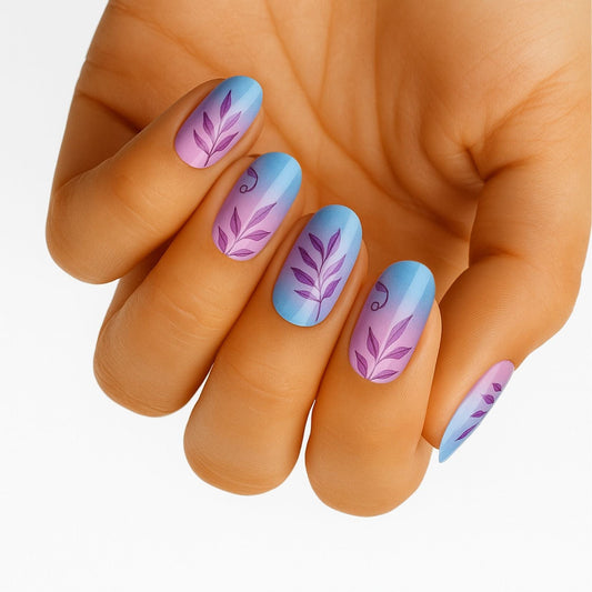 Blue to pink gradient nail wraps with purple botanical leaves on hand for at-home manicure