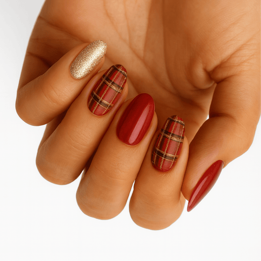 Festive nail art on hand featuring red tartan plaid and gold shimmer gel nail wraps