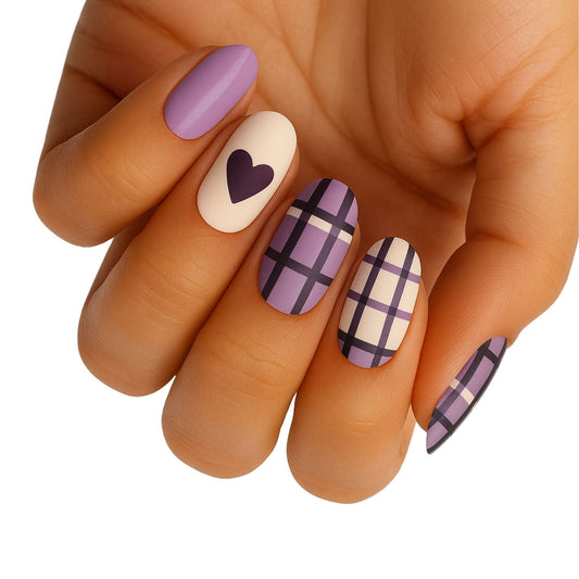 Hand wearing purple tartan plaid nail wraps with heart accent nail art design