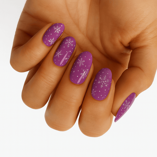 Purple glitter Christmas nail wraps with silver snowflakes applied on hand for festive manicure