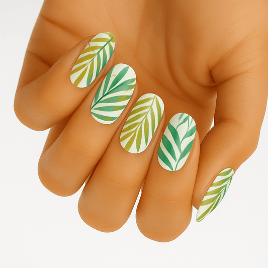 Green tropical fern leaf nail wraps on hand showing botanical nail art design