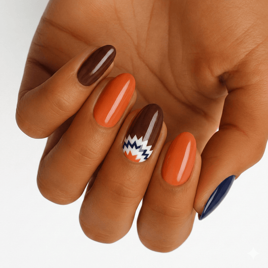 Glossy orange brown navy nail wraps with geometric chevron pattern on hand