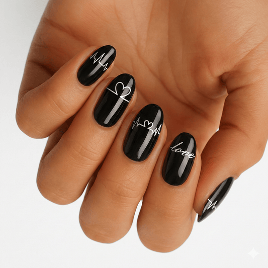 Black glossy nail wraps with white heart and typography designs on hand