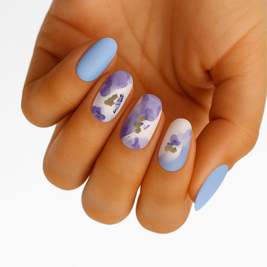 Blue and purple watercolour floral nail wraps with golden stamens on hand