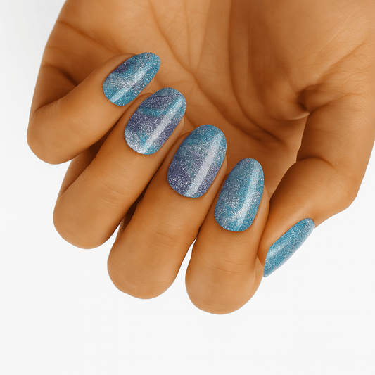 Blue holographic glitter nail wraps on hand with shimmering metallic finish