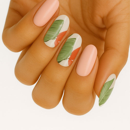 Hand showing tropical palm leaf nail wraps in green and peach with botanical patterns