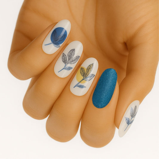 Blue glitter and botanical leaf non-UV nail wraps on hand showing elegant nature-inspired manicure design