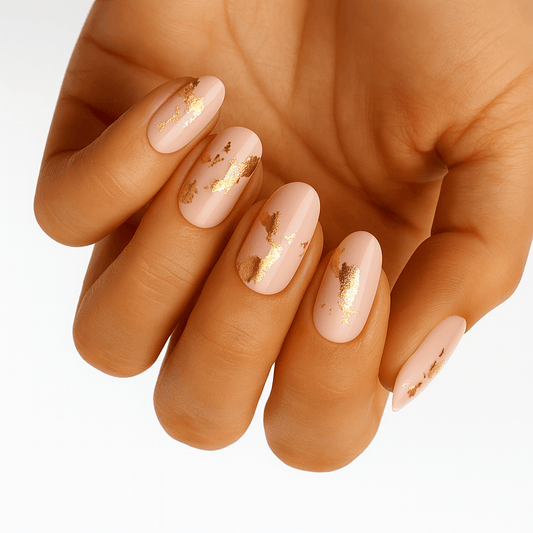 Nude gel nail wraps with gold foil accents on hand manicure