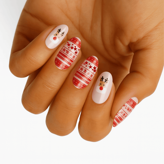 Christmas nail wraps on hand featuring red Fair Isle patterns and white reindeer designs