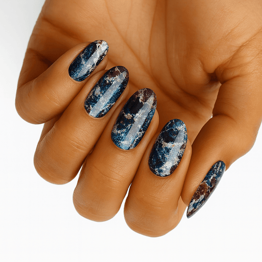 Blue and silver shattered marble nail wraps on hand showing metallic stone pattern