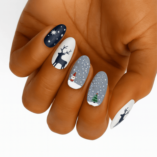 Christmas nail wraps on hand featuring navy snowflakes, white reindeer, grey dots