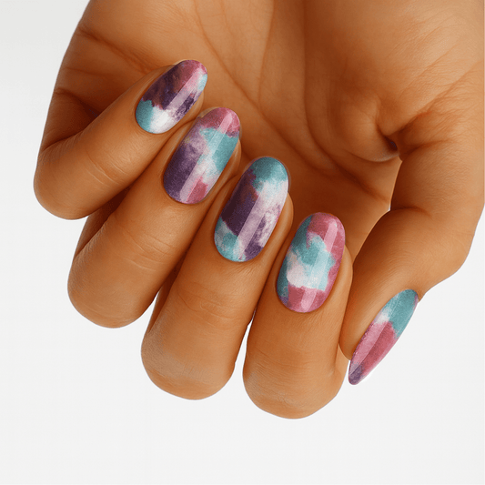 Hand displaying watercolour brushstroke nail wraps in purple, pink and teal pastel shades