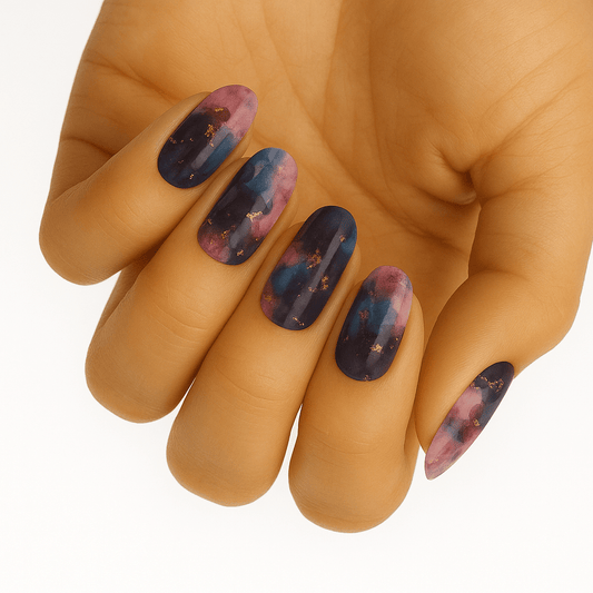 Hand wearing marble effect nail wraps in navy blue and pink tones