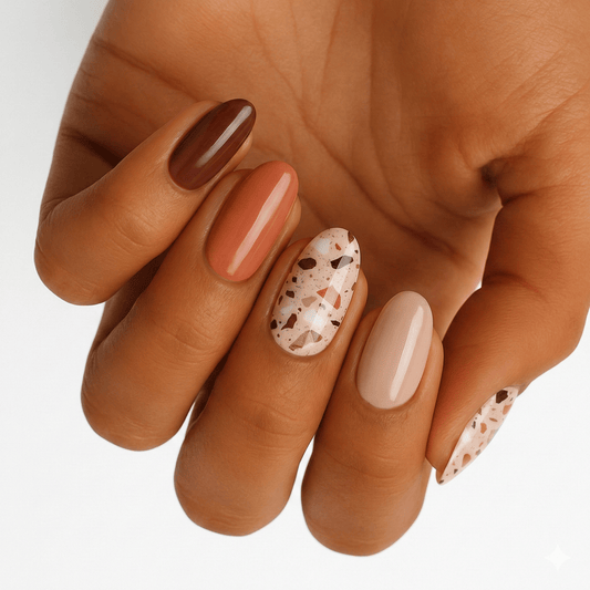 Terrazzo sunset nail wraps on hand showing neutral brown and cream speckled stone pattern