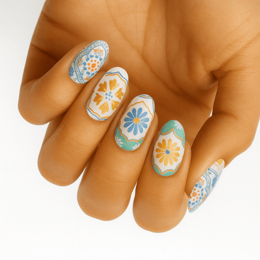 Hand wearing retro 70s floral nail wraps in blue, orange and green patterns