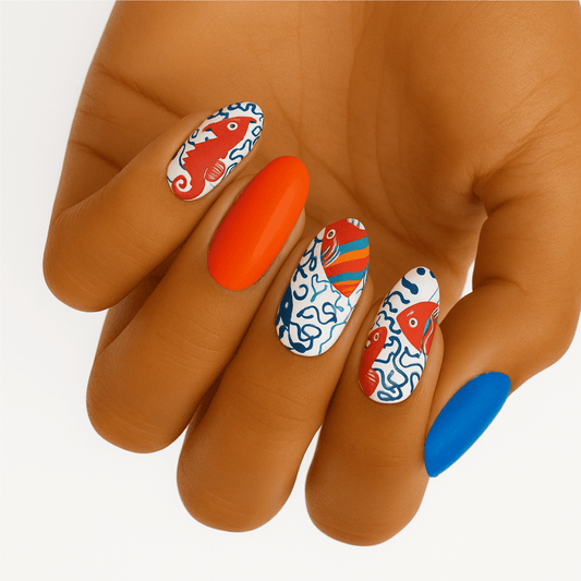 Hand showing ocean themed nail wraps with blue coral and orange designs for at-home manicure