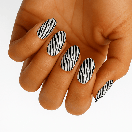 Black and white zebra print nail wraps on hand showing animal print pattern manicure