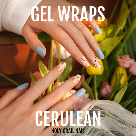 Blue gel nail wraps with colourful patterns applied on hands for at-home manicure