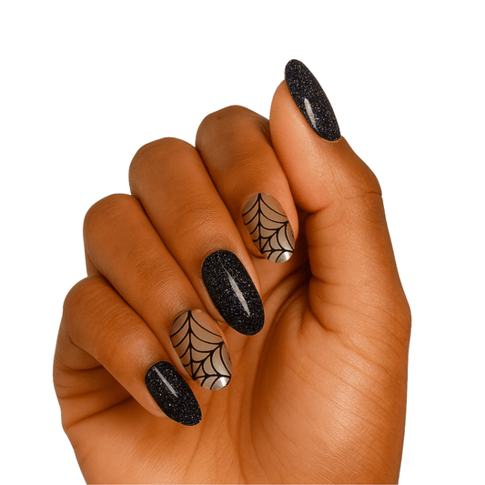 Black glitter gel nail wraps with spider web nail art on hand manicure