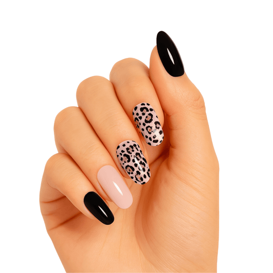 Hand showing black glossy and leopard print gel nail wraps manicure