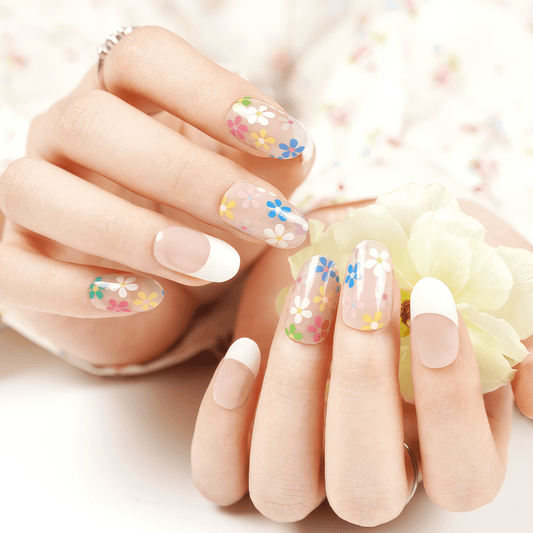 Clear gel nail wraps with delicate pastel flower patterns on natural manicured hands