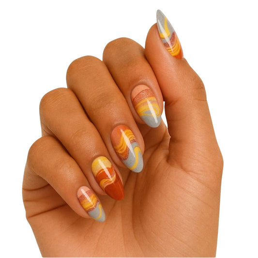 Hand wearing abstract orange gel nail wraps with flowing marble gradient design nail art